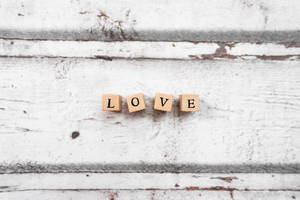 在質樸的白色木質背景上拼出 LOVE 的木塊。
