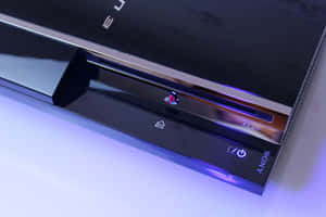 白色表面上帶有紫色發光燈光的黑色PlayStation 3主機。 — MacBook Pro 14 壁紙