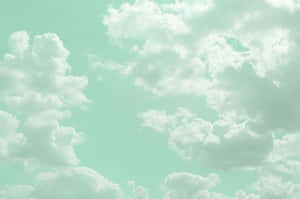 蓬鬆的白雲在平靜的日子裡漂浮在薄荷綠的天空中。