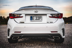 白色Lexus RC 350 F Sport在日落時分碎石路上的後視圖。