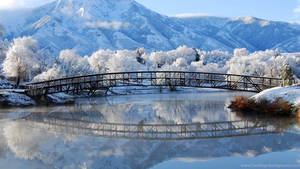 冬季河流上的雪橋與山脈倒影