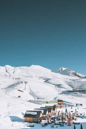 白雪覆蓋的山地滑雪度假村，設有木屋和滑雪纜車，在清澈的藍天下。 — Honor Pad GT2 Pro 壁紙
