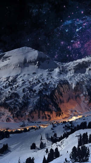 星空下白雪覆蓋的山脈，閃爍的滑雪度假村燈光。 — 鎖定螢幕 壁紙