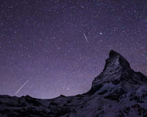 在繁星點點的夜空下，有兩顆流星的雪山。 — 夜空 壁紙