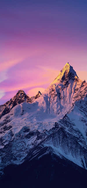 白雪覆蓋的山峰沐浴在金色的暮色中，映襯著紫色的天空。 — Pixel 8 Pro 壁紙