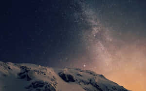 白雪覆蓋的山峰，在繁星點點的夜空下，銀河清晰可見。 — 平板電腦 壁紙