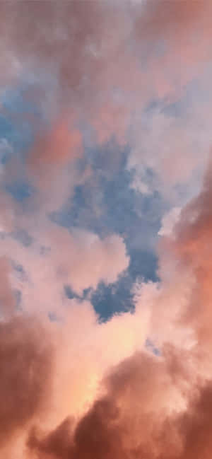 粉紅色和橙色的雲彩在日落時分飄過深藍色的天空。
