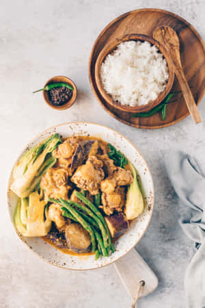 一碗奶油雞肉咖喱配青豆和米飯，置於淺灰色表面上。 — Huawei MatePad Air (2026) 壁紙