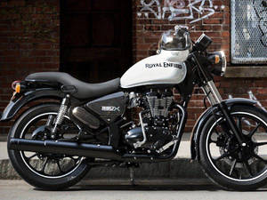 Royal Enfield 350X電單車停放在靠近塗鴉磚牆的人行道上。 — 皇室 壁紙