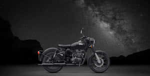 黑色 Royal Enfield 電單車在星空、銀河和山巒下。