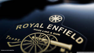 Royal Enfield 電單車標誌，金色文字和大炮徽章在黑色背景上。 — 皇室 壁紙