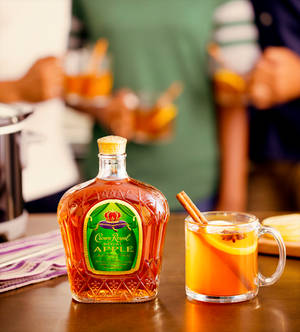 Crown Royal Apple威士忌酒瓶旁邊是一杯加了肉桂和八角的香料苹果酒。 — Honor Magic V 壁紙