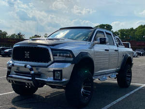 鍍鉻Ram pickup truck，大輪胎，停在多雲天空下的停車場。 — 汽車 壁紙