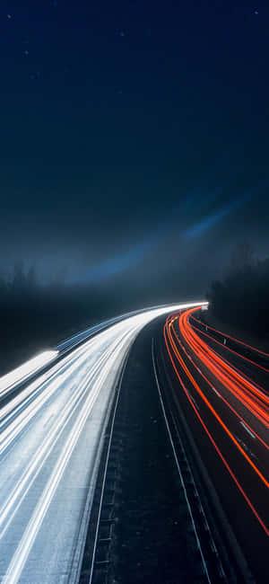星空下，夜間高速公路上的白色和紅色汽車燈光條紋。