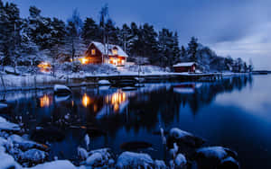 夜間湖邊被雪覆蓋的小屋，溫暖燈光倒映在水中