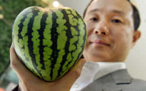 穿西裝男子手持心形西瓜