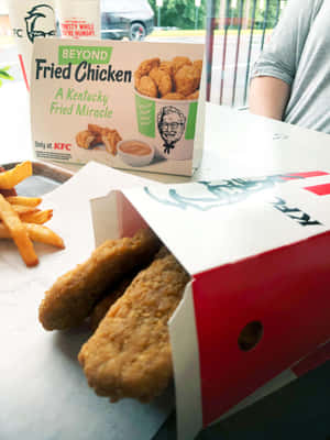 KFC Beyond Fried Chicken 盒裝雞柳和薯條放在桌上。