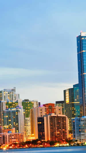 黃昏城市天際線，發光建築物與水面倒影