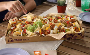 Taco Bell玉米片配芝士、鱷梨醬和配料，放在木桌上。