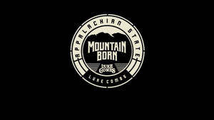圓形標誌，帶有山脈輪廓和文字 Appalachian State Mountain Born Luke Combs，位於黑色背景上。