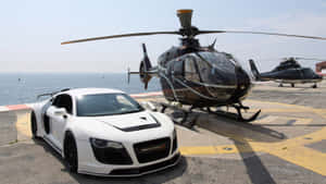 白色跑車和黑色直升機在海邊直升機停機坪上。