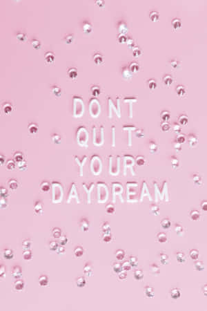 粉紅色背景，白色3D文字寫著「DON'T QUIT YOUR DAYDREAM」，周圍環繞著銀色水鑽。 — Lenovo Legion Y900 13 壁紙