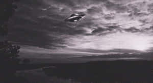 UFO在多雲天空下盤旋在黃昏的黑暗景觀之上。