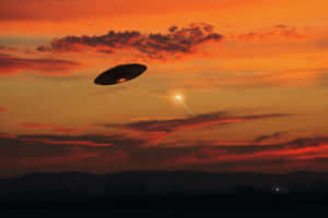 UFO在日落時飛越山脈，天空呈現橙色。