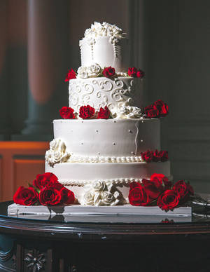 優雅的白色結婚蛋糕，在深色桌上飾有紅白玫瑰。