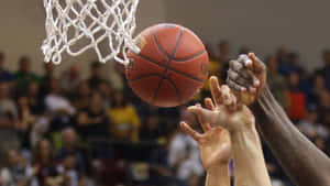 兩名籃球運動員在球穿過籃網時爭奪投籃。