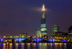 倫敦夜景天際線，碎片大廈和泰晤士河上燈火通明的橋樑。
