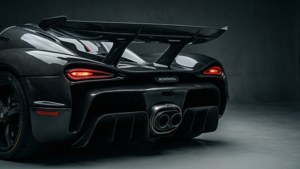 黑色Koenigsegg超跑後視圖，在黑暗攝影棚中帶有發光尾燈。