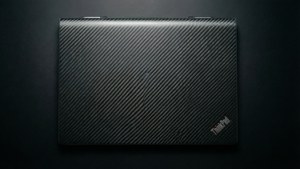 關閉的碳纖維ThinkPad筆記本電腦在深色背景上