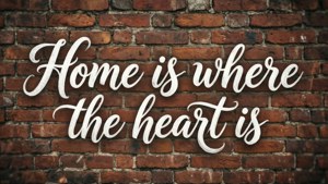 紅磚牆上的白色草書引文，寫著「Home is where the heart is」 — 磚牆 壁紙