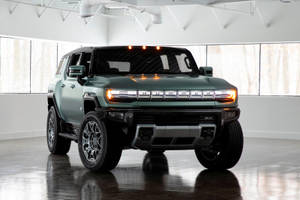 綠色Hummer EV SUV在明亮的白色工作室中，地板具有反射效果。