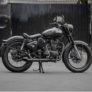經典黑色 Royal Enfield 電單車停泊在行人路近金屬圍欄處。 — 皇室 壁紙