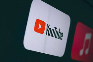 YouTube應用程式圖示在黑暗屏幕上發光，旁邊有一個音樂應用程式圖示。