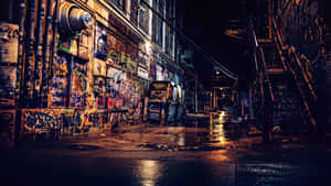 夜晚佈滿塗鴉的後巷，濕漉漉的路面反射著霓虹燈光。 — 藝術 壁紙