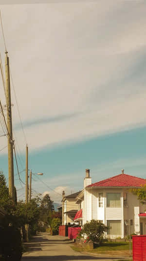 郊區街道，有白色房屋和紅色屋頂，天空部分多雲。
