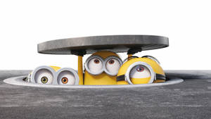 三個卡通Minions從沙井蓋探出頭來，睜大眼睛。