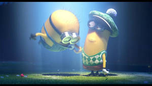 兩個卡通 minions，一個穿著綠色格仔服裝和帽子站立，另一個在藍色聚光燈下漂浮。