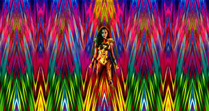 神奇女俠身穿金色盔甲，背景為迷幻彩虹鋸齒圖案。