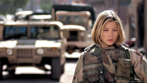 身穿迷彩服的女兵站在街上，身後有軍用車輛。 — 軍事動圖 壁紙