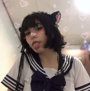 穿著水手服、戴著貓耳的人伸出舌頭，周圍有閃爍的心形。