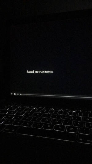 手提電腦屏幕顯示「Based on true events.」及黑暗中鍵盤。