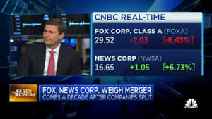 CNBC主播報道Fox與News Corp合併，屏幕上顯示股票數據。
