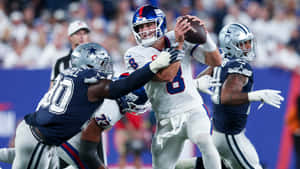 NFL四分衛在現場比賽中受到兩名防守球員的壓力。