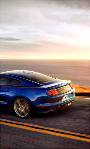 日落時分在海岸高速公路上疾馳的藍色Mustang GT。 — 沙灘 壁紙