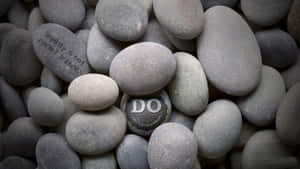光滑灰色石頭，上面刻有勵志短語，例如「Simplicity is not rocket science」和「DO WHAT'S WORTH DOING」。