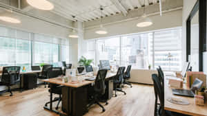 開放式辦公室，舖有木地板、黑色椅子，透過大型窗戶可欣賞城市景觀。